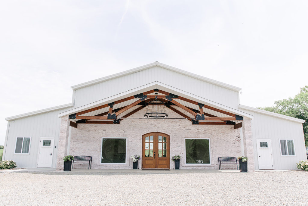 A white barn wedding venue with cedar accents.